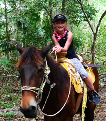 Boy riding a horse on nature trails at Loma Bonita Ecopark